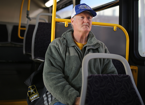 Older gentleman riding the bus with an U,S, Army jacket.