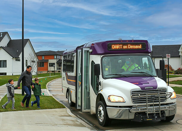 Father with his two sons walking towards the DART on Demand vehicle.