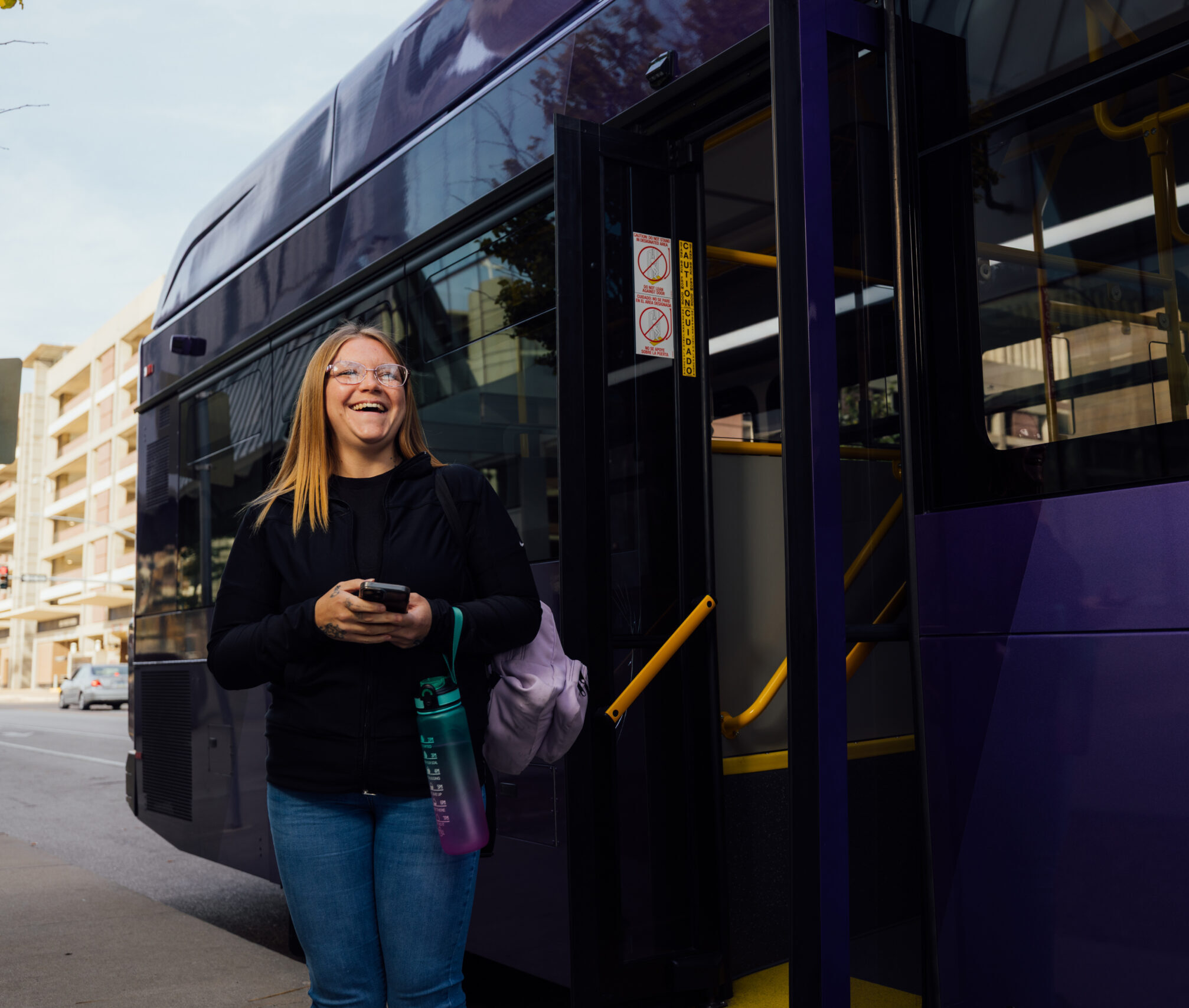 Happy woman getting off the public bus