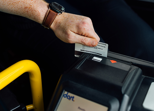 A person inserting a fare card into a DART bus fare payment machine